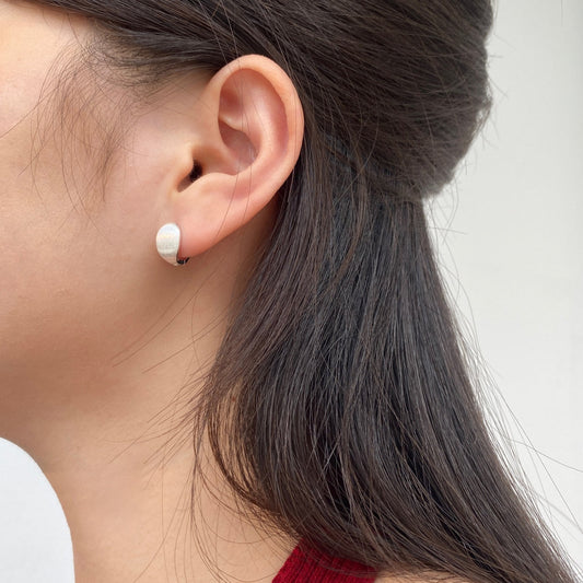 Aretes Huggie Domo Suave usados cerca del lóbulo para la guía de tamaños Huggie de Valesstra