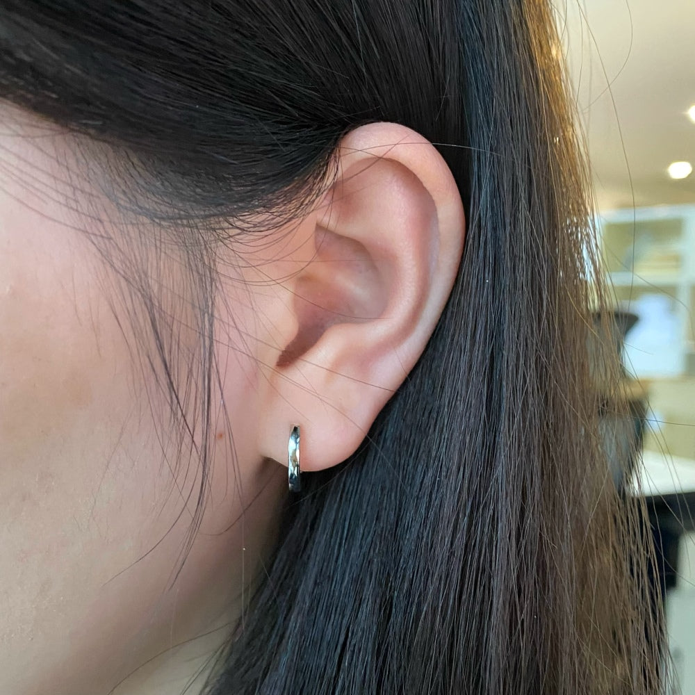 Classic Slim Huggie Hoops in silver finish, styled on model
