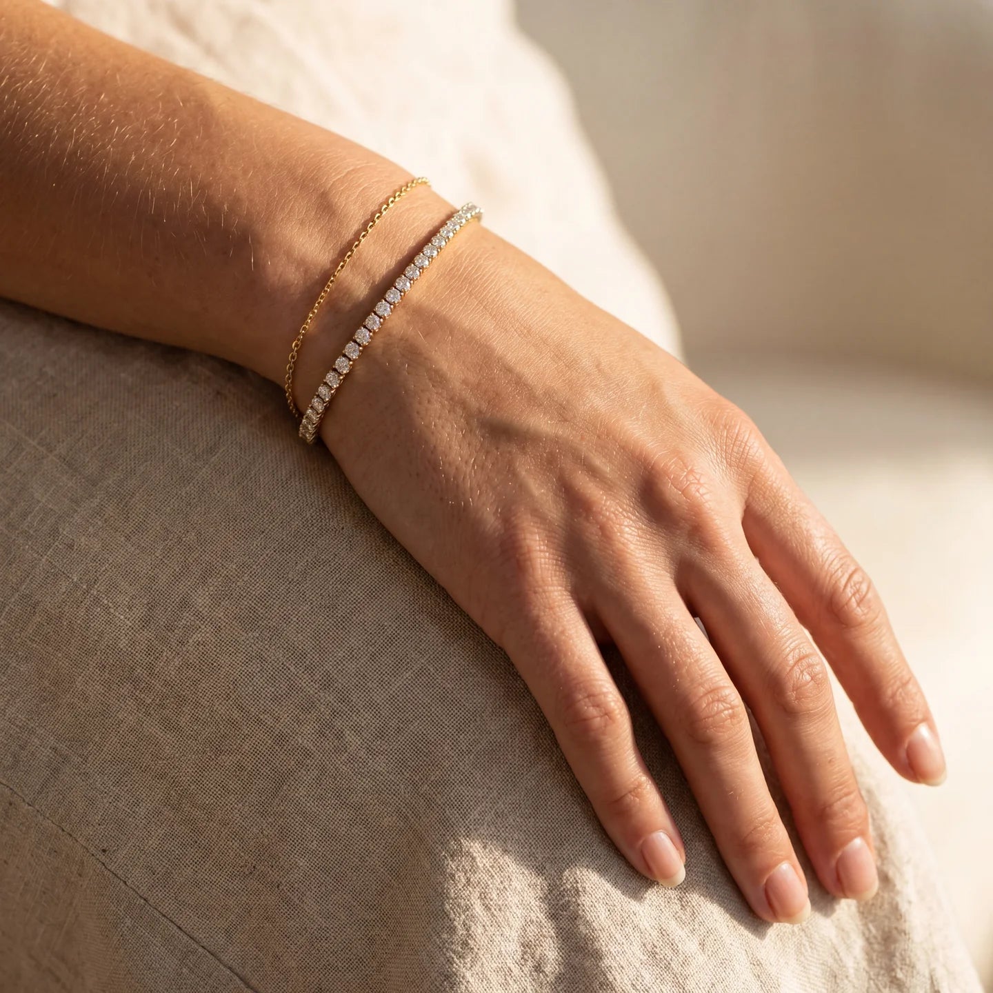 Close-up of delicate gold and pavé bracelets.
